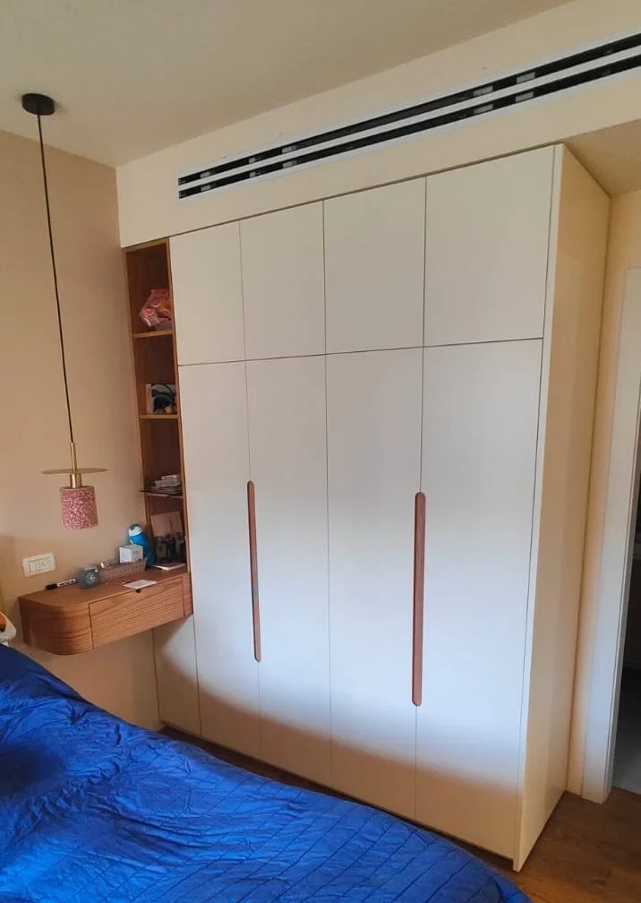 ארון חדר שינה מהרצפה לתקרה בגימור לבן מאט, עם ידיות עץ דקות ואנכיות